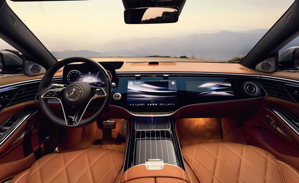 vehicle interior view tan leather seats digital dashboard wide display center console ambient lighting mountain horizon.